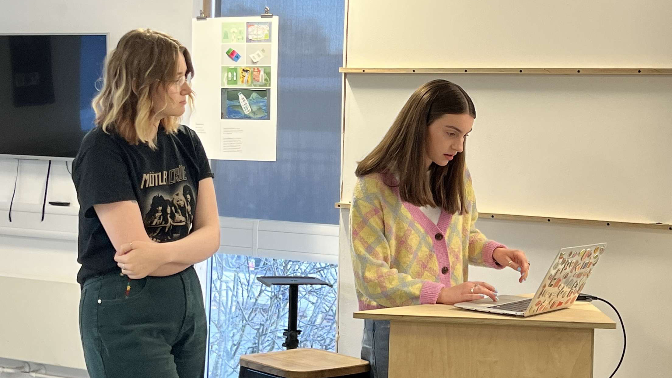 a photograph of two women standing at a presentation